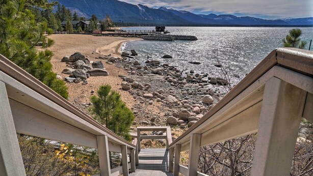 A staircase leading to a beach with a view of a lake and mountains. - Deck & Beach Access: Lake Tahoe Shoreside Retreat! (Zephyr Cove)