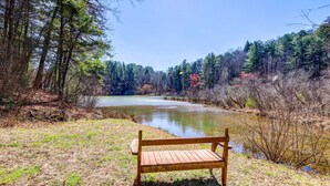 A wooden bench by a lake surrounded by trees. - Lakefront Blue Ridge Cabin w/ Hot Tub! (Blue Ridge)