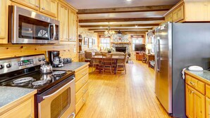 A spacious kitchen with wooden cabinets, a large stove, a microwave, and a refrigerator. - Lakefront Blue Ridge Cabin w/ Hot Tub! (Blue Ridge)