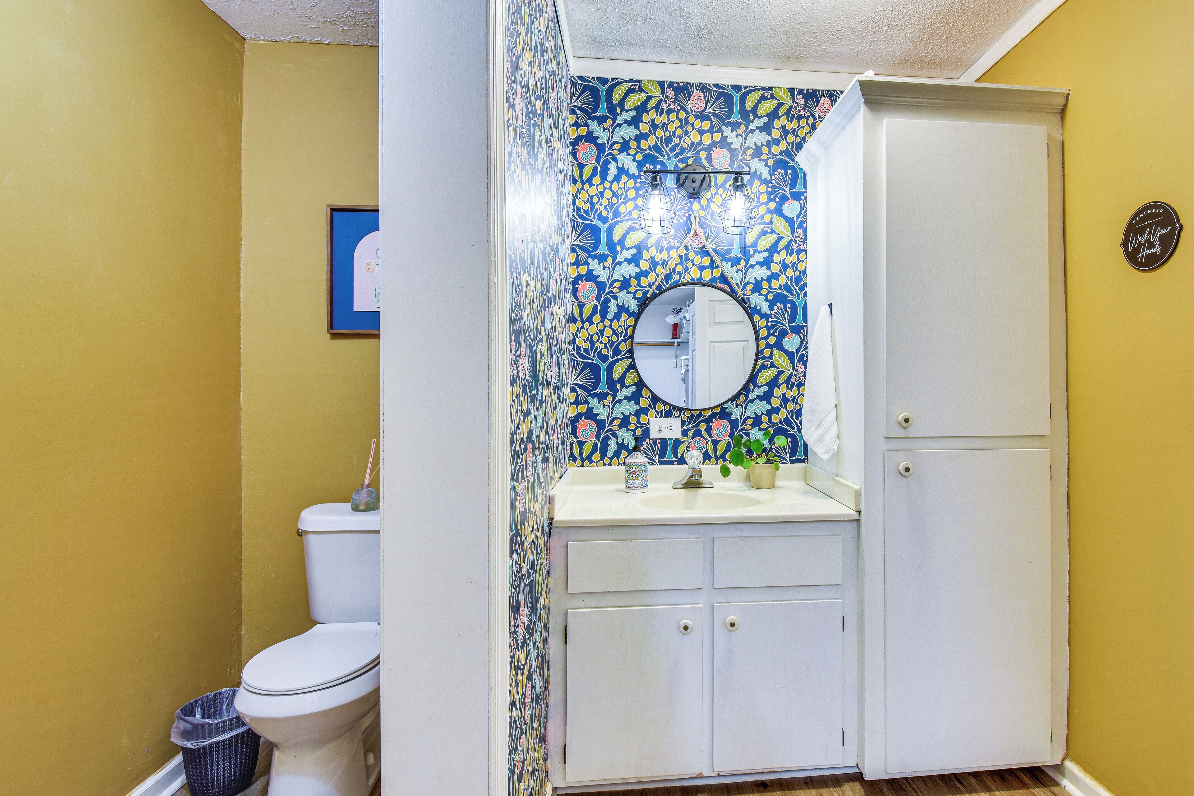 A bathroom with a toilet, a sink with a mirror, and a cabinet.