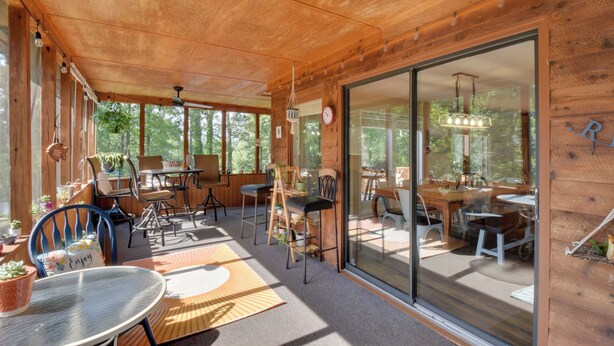 Eine Holzhütte mit Essbereich, einem Tisch und Stühlen sowie einem großen Fenster.