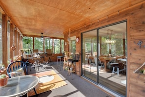 A wooden cabin with a dining area, chairs, and a table. - Waterfront Casabella Cottage w/ Kayaks & Fishing (Mount Airy)