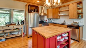 A modern kitchen with wooden cabinets, stainless steel appliances, and a central island.