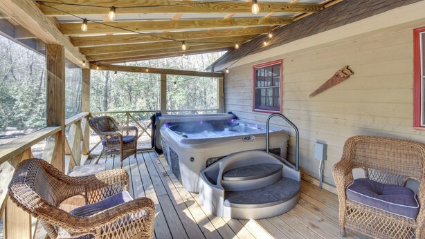 A wooden deck with wicker chairs, a hot tub, and a rustic interior. - Cozy Creekside Mountain Escape w/ Hot Tub! (Sautee Nacoochee)