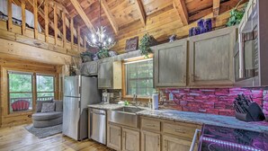 A rustic kitchen with wooden beams, a stone backsplash, and a built-in stove. - 'deer Haven' Cabin: 5 Mi to Dtwn Blue Ridge! (Blue Ridge)