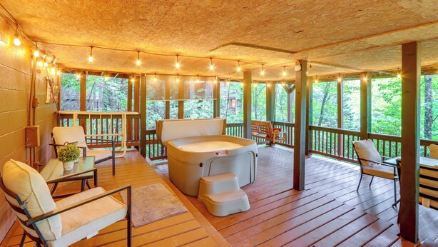 A wooden deck with a hot tub, seating, and string lights. - 'deer Haven' Cabin: 5 Mi to Dtwn Blue Ridge! (Blue Ridge)