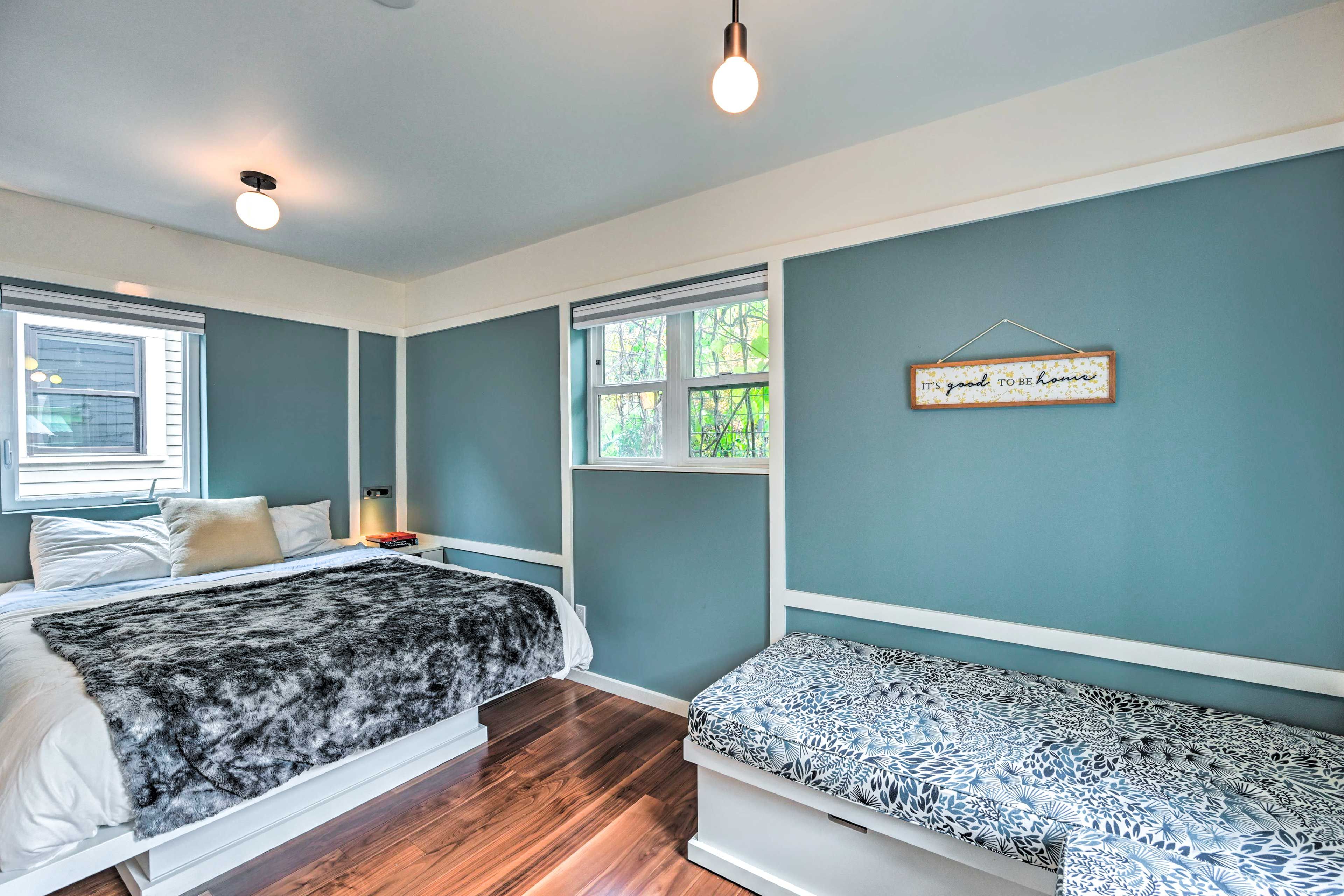 A bedroom with two beds, a window, and a wall-mounted sign.