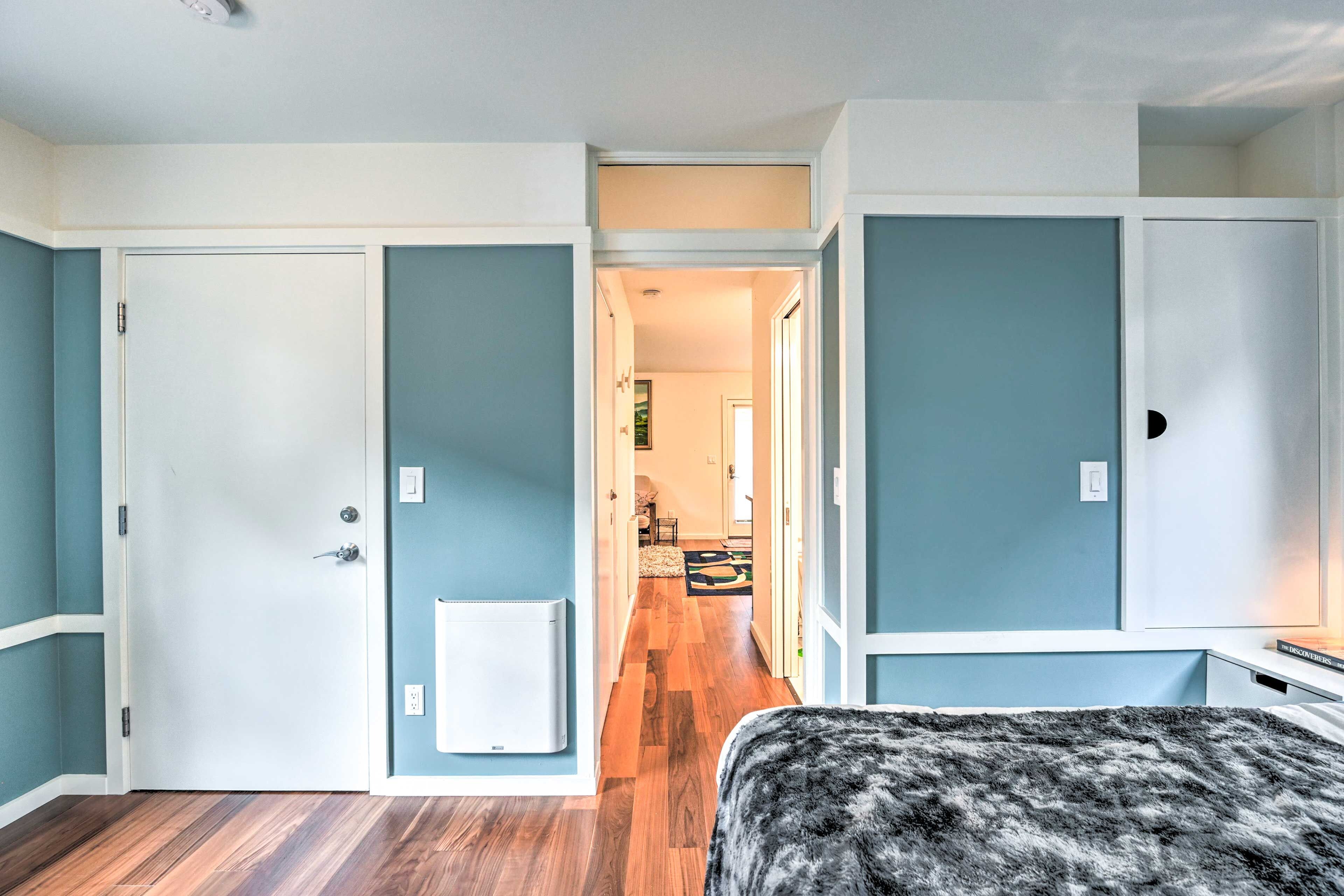 A room with a bed, a radiator, and a door leading to another room.