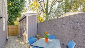 A patio with a table and chairs, a small shed, and a wooden fence. - < 1 Mi to Waterfront: Old Town Alexandria Home! (Alexandria)