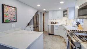 A modern kitchen with white cabinetry, stainless steel appliances, and a large island. - < 1 Mi to Waterfront: Old Town Alexandria Home! (Alexandria)