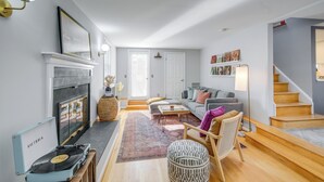 A living room with a fireplace, a sofa, a coffee table, and a staircase. - < 1 Mi to Waterfront: Old Town Alexandria Home! (Alexandria)