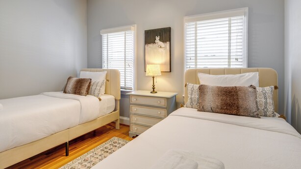 A bedroom with two beds, a nightstand with a lamp, and a painting on the wall. - < 1 Mi to Waterfront: Old Town Alexandria Home! (Alexandria)