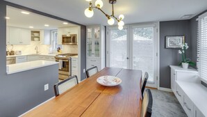 A modern kitchen with white cabinets, a wooden dining table, and a chandelier. - < 1 Mi to Waterfront: Old Town Alexandria Home! (Alexandria)