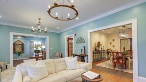 A living room with a beige sofa, a round coffee table, and a chandelier. There is a dining area visible through an open door. - 'the Inn on Second' - Jackson Family Home! (Jackson)