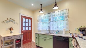 A kitchen with a wooden door, a sink, a dishwasher, and a cabinet with drawers. - 'the Inn on Second' - Jackson Family Home! (Jackson)