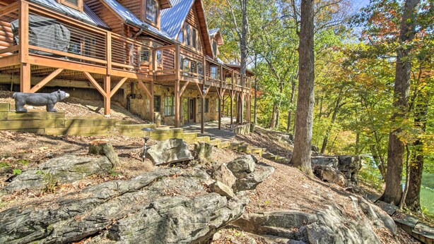 A log cabin with a deck overlooking a rocky terrain and a forested area. - Calhoun Cabin w/ River View + Wraparound Deck (Calhoun)