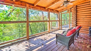 A wooden deck with a ceiling fan, wicker furniture, and a view of trees. - Calhoun Cabin w/ River View + Wraparound Deck (Calhoun)