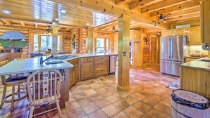 A spacious kitchen with wooden beams, a large island, and stainless steel appliances. - Calhoun Cabin w/ River View + Wraparound Deck (Calhoun)