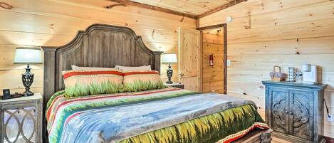 Un dormitorio de cabaña de madera con cama, mesitas de noche y un armario.