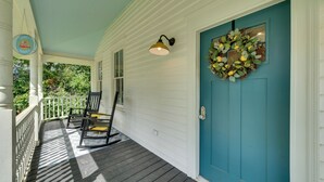 A porch with a blue door, a hanging wreath, and a porch light. - Restored Home Near Downtown Thomasville (Thomasville)