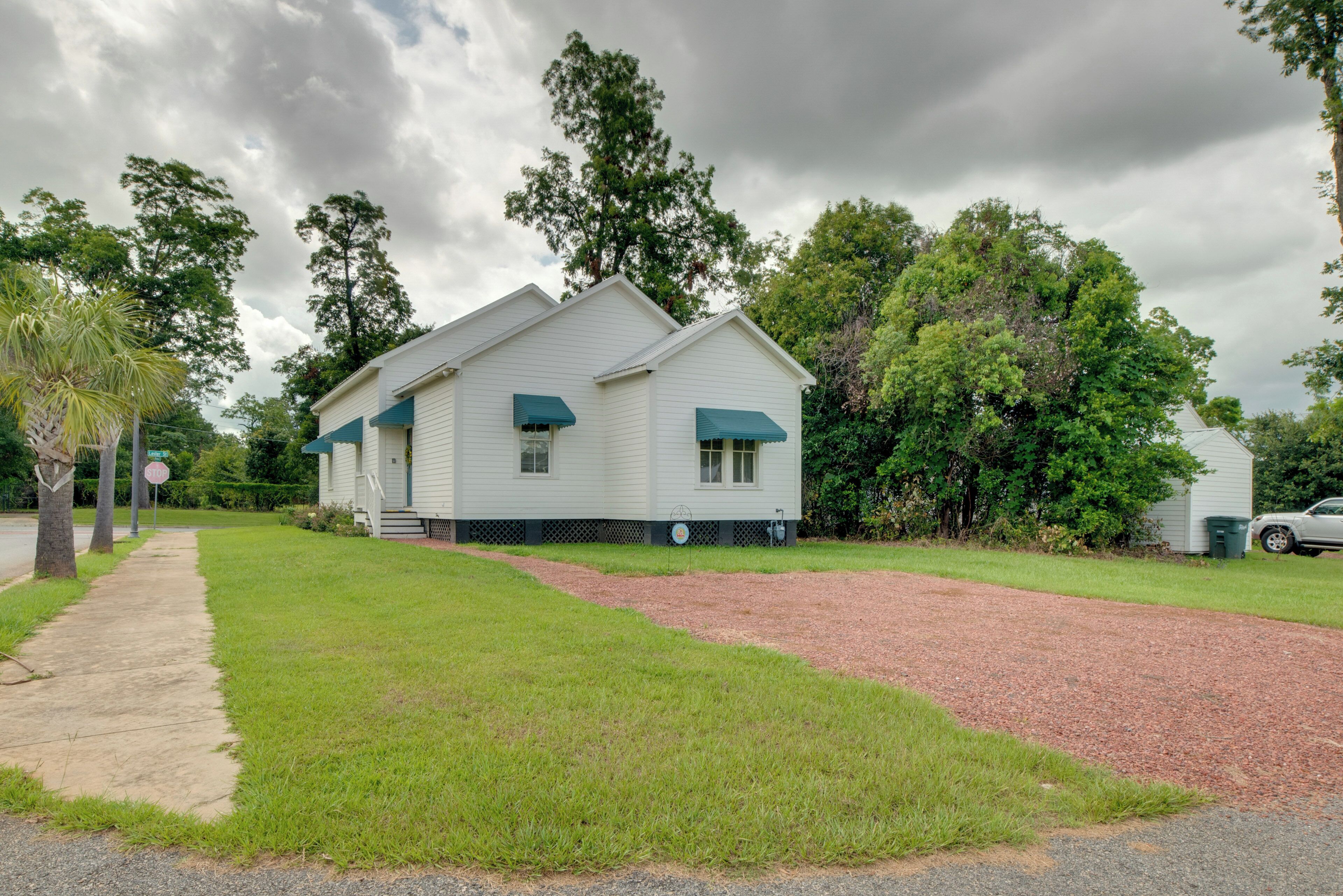 A single-story house with a front porch, a driveway, and a well-maintained lawn.