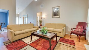 Ein Wohnzimmer mit zwei Sofas, einem Couchtisch und einem roten und beigen Teppich.