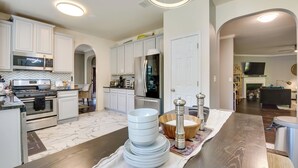 A modern kitchen with white cabinets, stainless steel appliances, and a marble floor. - Snellville Abode < 9 Mi to Stone Mtn Park! (Snellville)