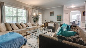 A living room with a sofa, a coffee table, and a ceiling fan. - Snellville Abode < 9 Mi to Stone Mtn Park! (Snellville)