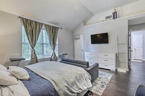 A bedroom with a bed, bedside tables, a TV, a wardrobe, and a door leading to another room. - Snellville Abode < 9 Mi to Stone Mtn Park! (Snellville)