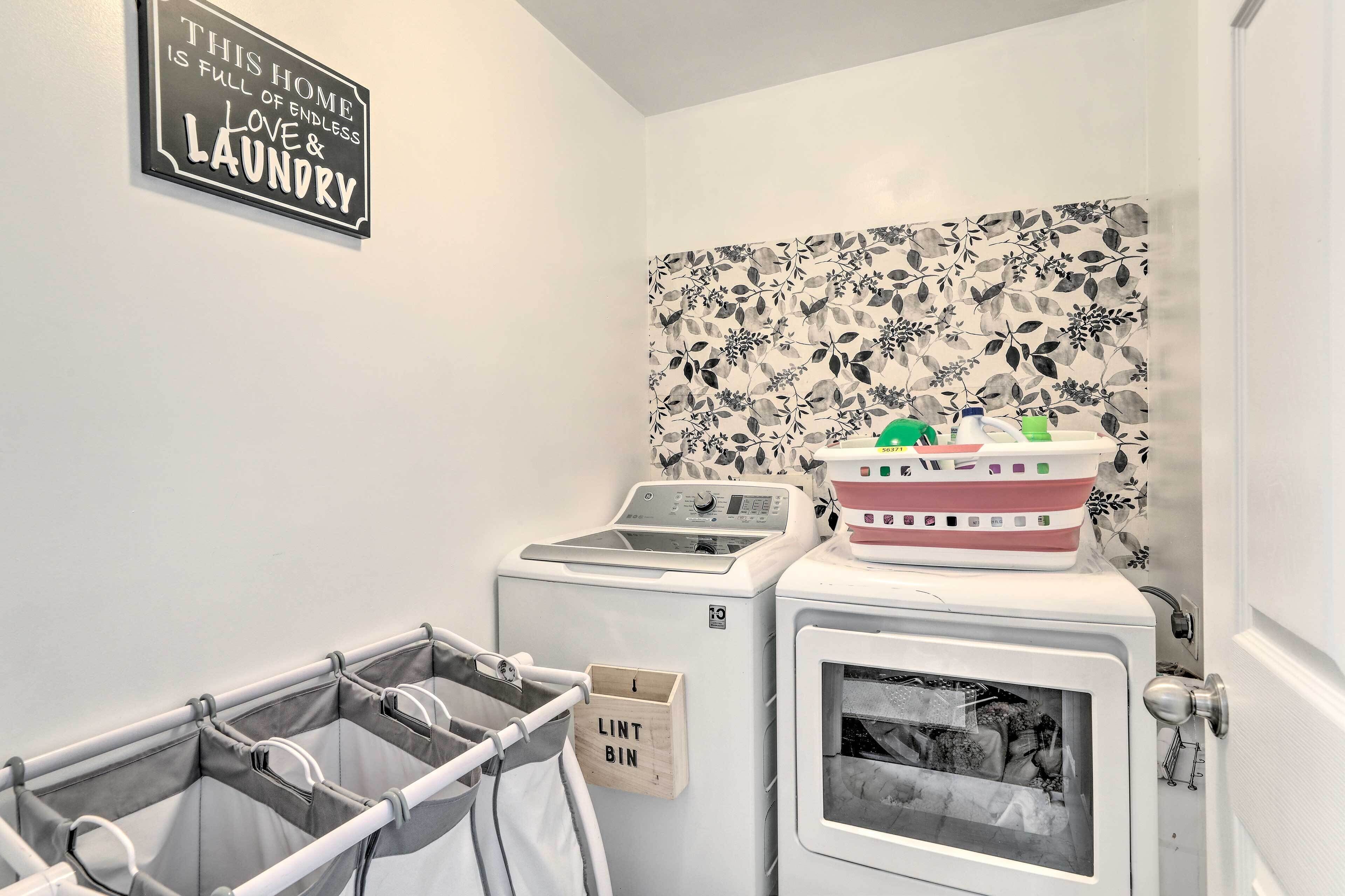 A laundry area with a washing machine, dryer, and a lint bin.