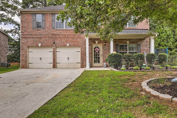 A two-story brick house with a front garage, a covered porch, and a well-maintained lawn. - Snellville Abode < 9 Mi to Stone Mtn Park! (Snellville)