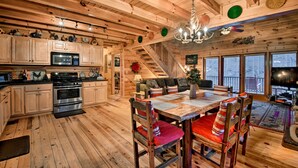 L'intérieur d'une cabane en bois comprend une cuisine, un coin repas et un escalier.