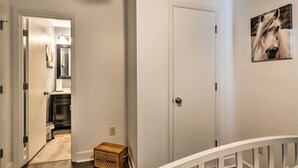 A hallway with a white door, a small wooden box, and a framed picture on the wall. - Junction City Home: Large Yard & Deck! (Junction City)