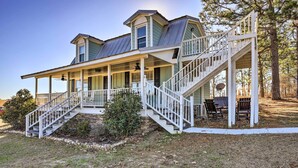 A two-story house with a covered porch, a staircase, and a satellite dish. - Junction City Home: Large Yard & Deck! (Junction City)