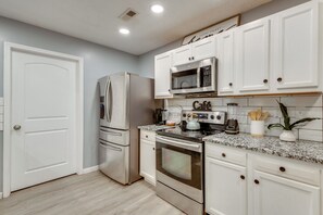 A modern kitchen with stainless steel appliances, white cabinetry, and a granite countertop. - Near Airport, Private Yard! Atlanta Rental (Atlanta)