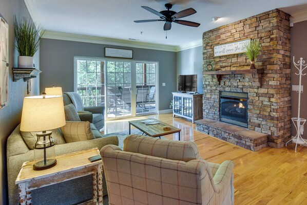 A living room with a fireplace, a ceiling fan, and a view to the outside. - Clayton Resort Getaway w/ Pool Access, Pickleball! (Clayton)
