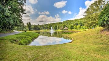 A serene park with a pond, gazebo, and lush greenery.