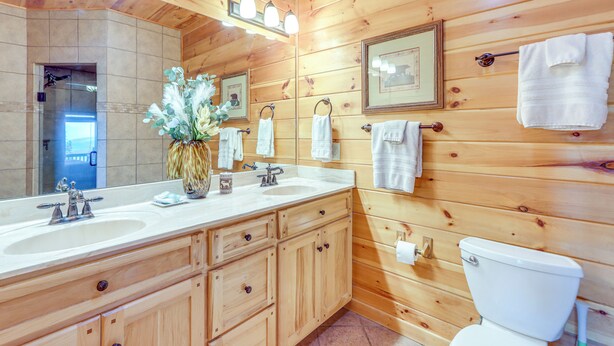A wooden-paneled bathroom with two sinks, a toilet, and a large mirror. - Mineral Bluff 'bear Ridge Cabin' w/ Hot Tub! (Mineral Bluff)