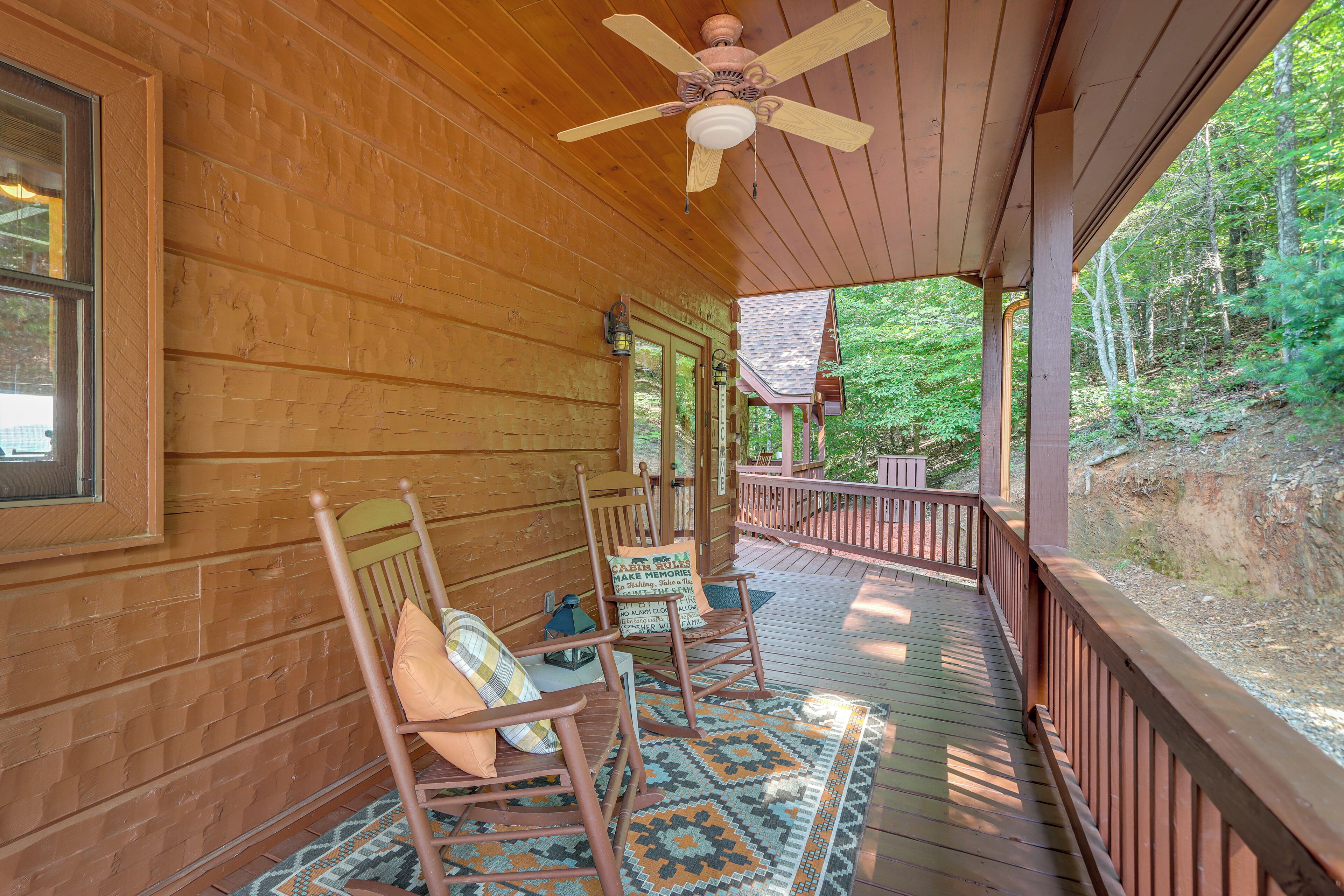 A wooden porch with rocking chairs and a patterned rug.