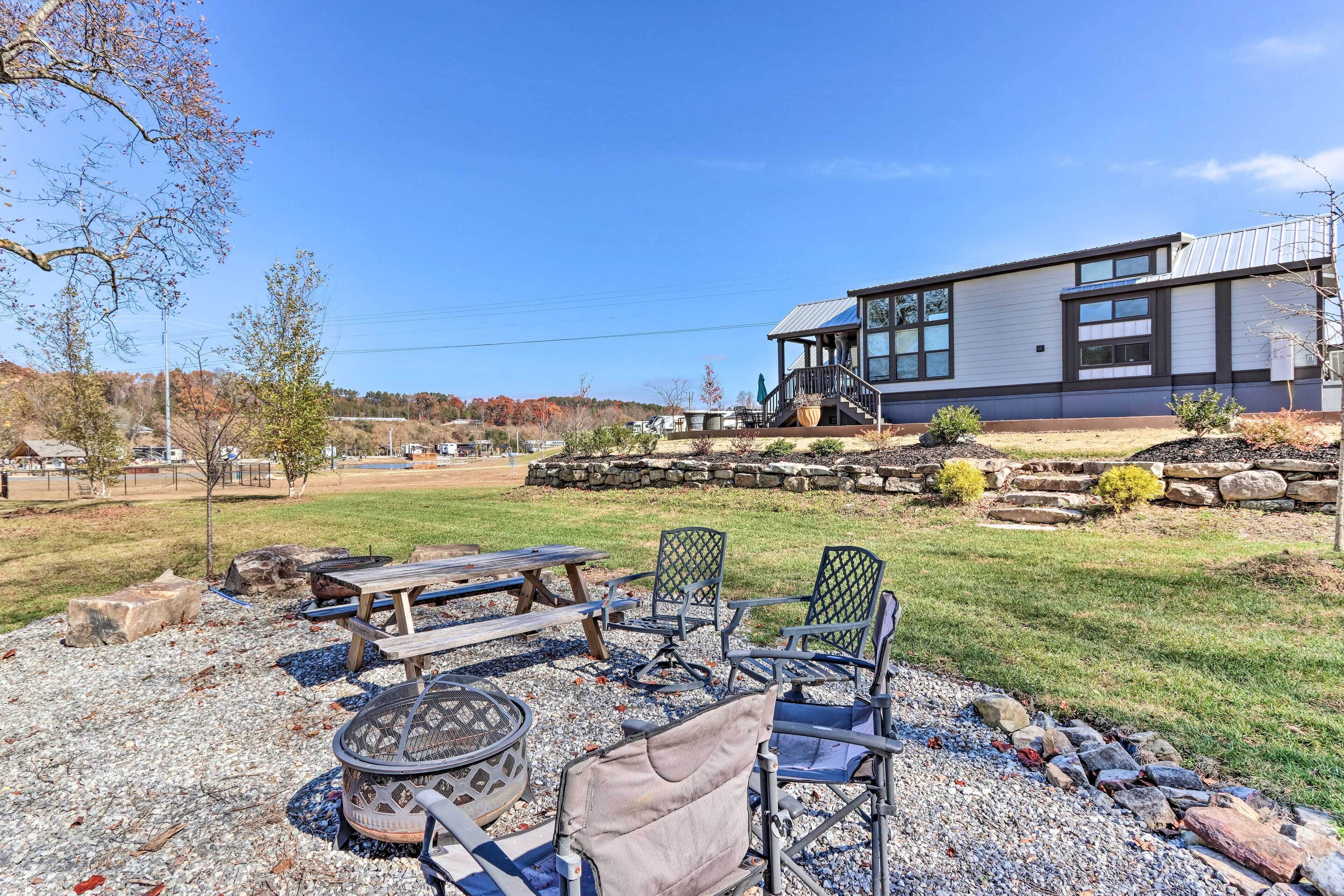 A modern house with a stone patio, outdoor seating, and a fire pit.