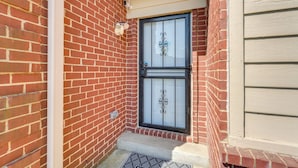 A brick house with a black metal door and a welcome mat. - Horn Lake Vacation Rental ~ 14 Mi to Memphis! (Horn Lake)