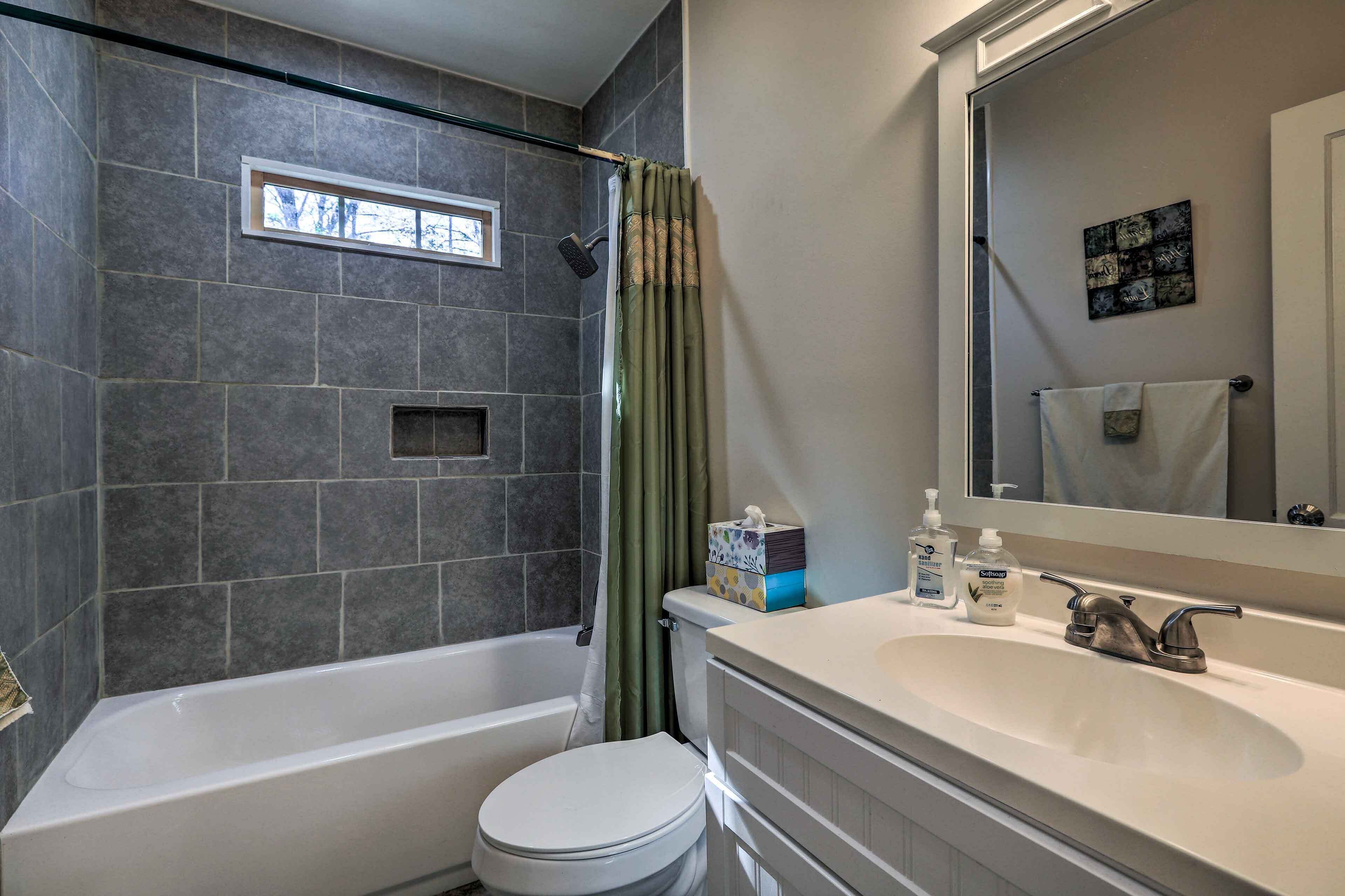 A bathroom with a bathtub, toilet, and sink.