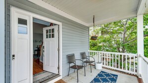 A porch with a white door, two chairs, a blue patterned rug, and a white railing. - Inviting Norfolk Family Retreat: 1 Block to Beach! (Norfolk)