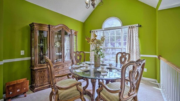 A dining room with a glass table, wooden chairs, a china cabinet, and a window with curtains. - Spacious Acworth Home w/ Deck ~ 1 Mi to Lake (Acworth)