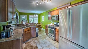 A kitchen with wooden cabinets, a stainless steel refrigerator, a microwave, a stove, and a sink. - Spacious Acworth Home w/ Deck ~ 1 Mi to Lake (Acworth)