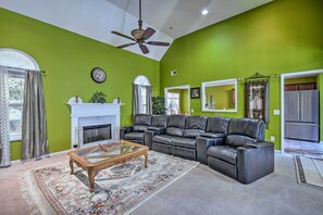 A living room with a fireplace, leather sofa, and a ceiling fan. - Spacious Acworth Home w/ Deck ~ 1 Mi to Lake (Acworth)