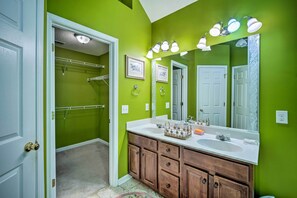 A bathroom with green walls, a white sink, and a large mirror with lights. - Spacious Acworth Home w/ Deck ~ 1 Mi to Lake (Acworth)