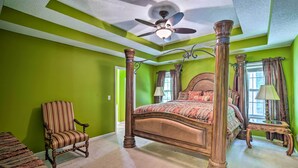 A four-poster bed in a room with green walls, a ceiling fan, and a wooden chair. - Spacious Acworth Home w/ Deck ~ 1 Mi to Lake (Acworth)