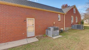A brick building with a door, windows, and an air conditioning unit. - 8 Mi to Broadway: Wfh-friendly Nashville Duplex! (Nashville)