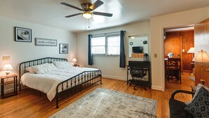 A bedroom with a bed, a desk, a chair, a ceiling fan, and a window with curtains. - 8 Mi to Broadway: Wfh-friendly Nashville Duplex! (Nashville)